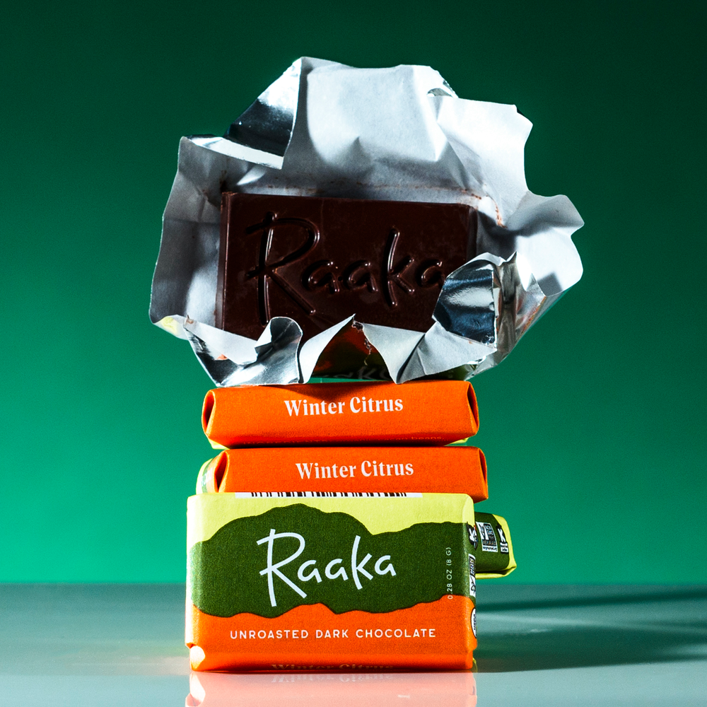 Open wrapper of Raaka Chocolate Winter Citrus Minis with stack of minis